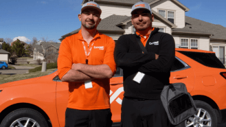 Image of two technicians standing in front of a car