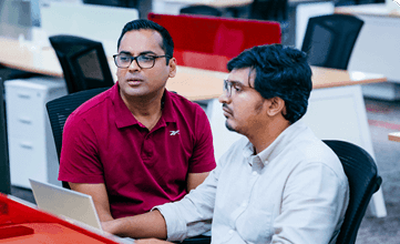 Two men chatting at a computer