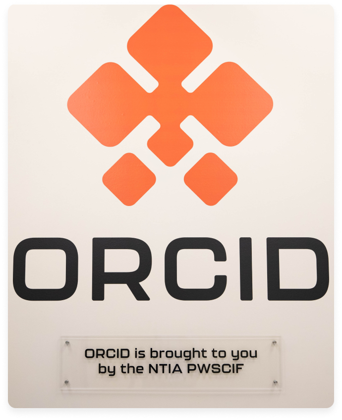 A large ORCID sign mounted on a wall with the text 'ORCID is brought to you by the NTIA PWSCIF' below it.